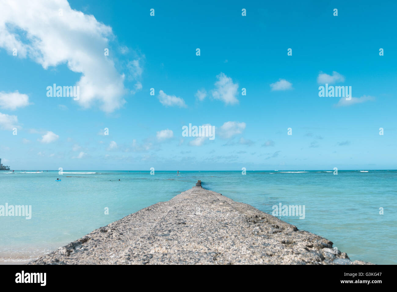 path walk way wall extend to clean blue sea on nice blue cloud sky vacation day. Stock Photo