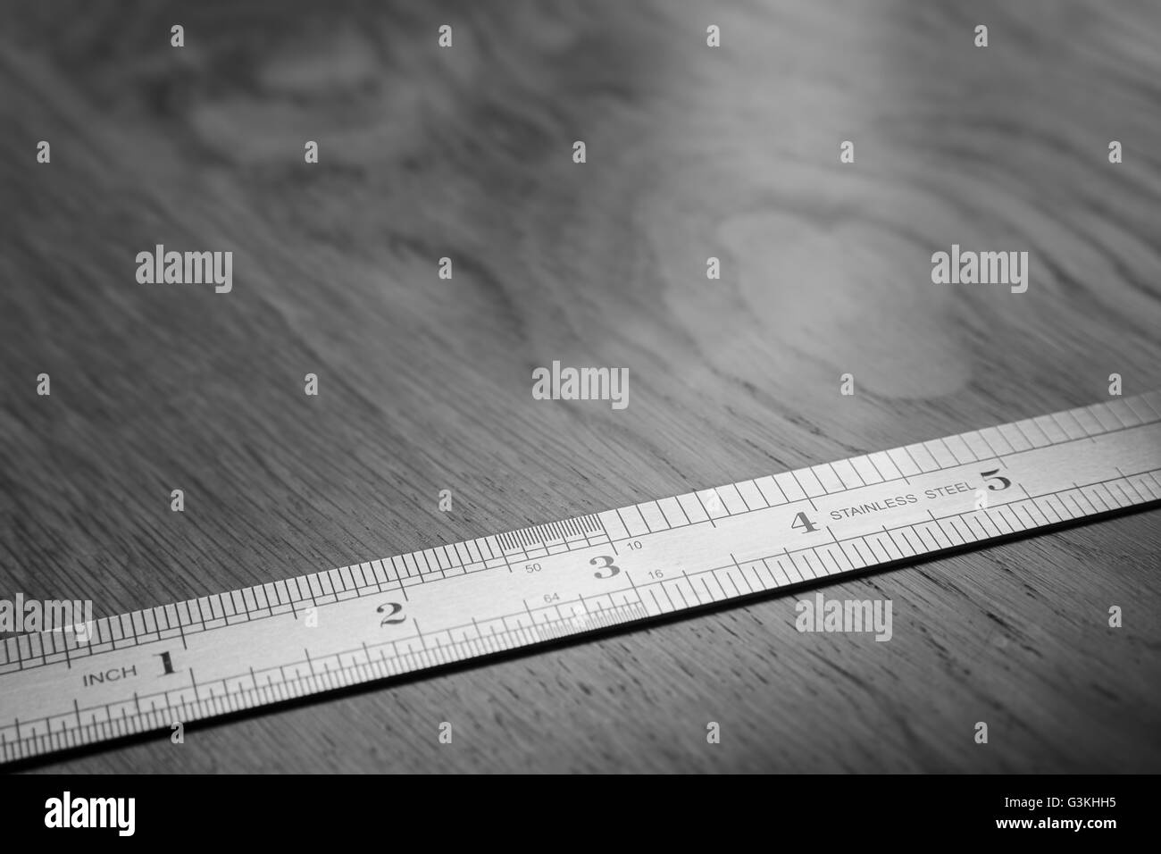 Metal ruler on wooden table Stock Photo