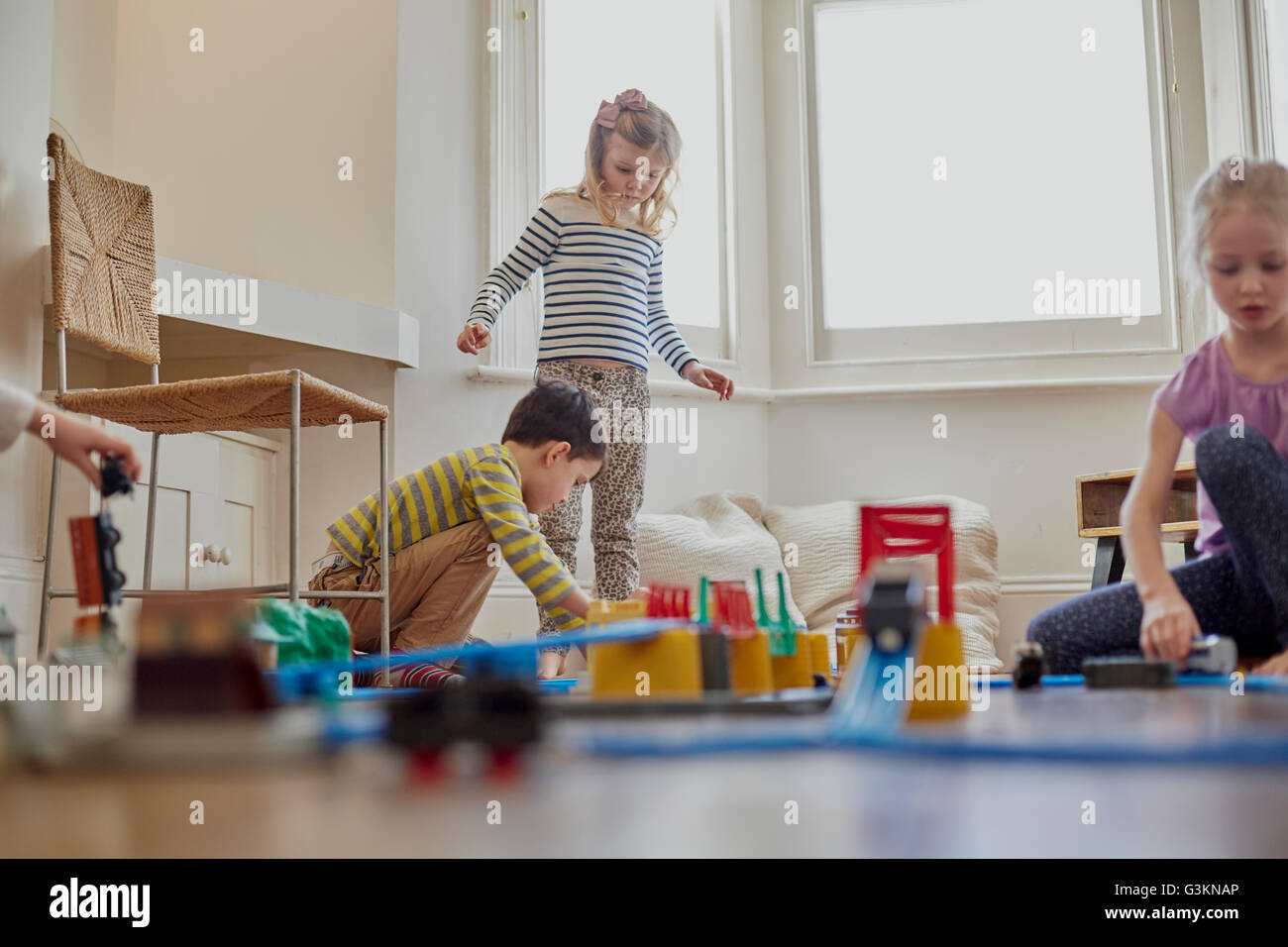 Young children playing with toy train set Stock Photo