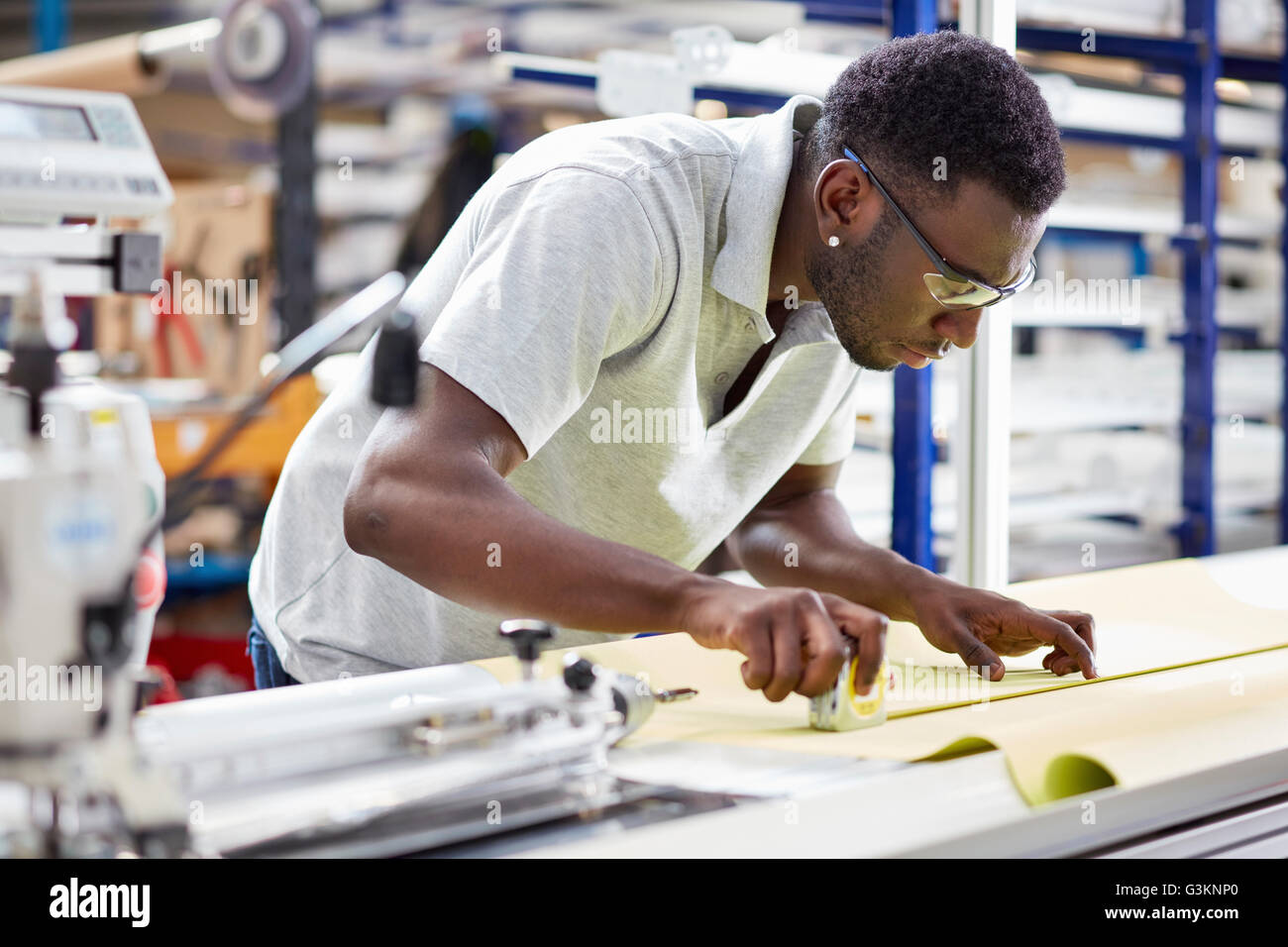 Worker assembling roller blind on production line in factory Stock Photo