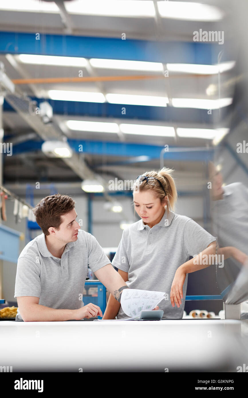 Manager advising female worker on production line in factory Stock Photo