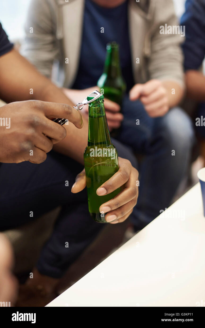 Cropped view of mans hands opening bottle of beer Stock Photo