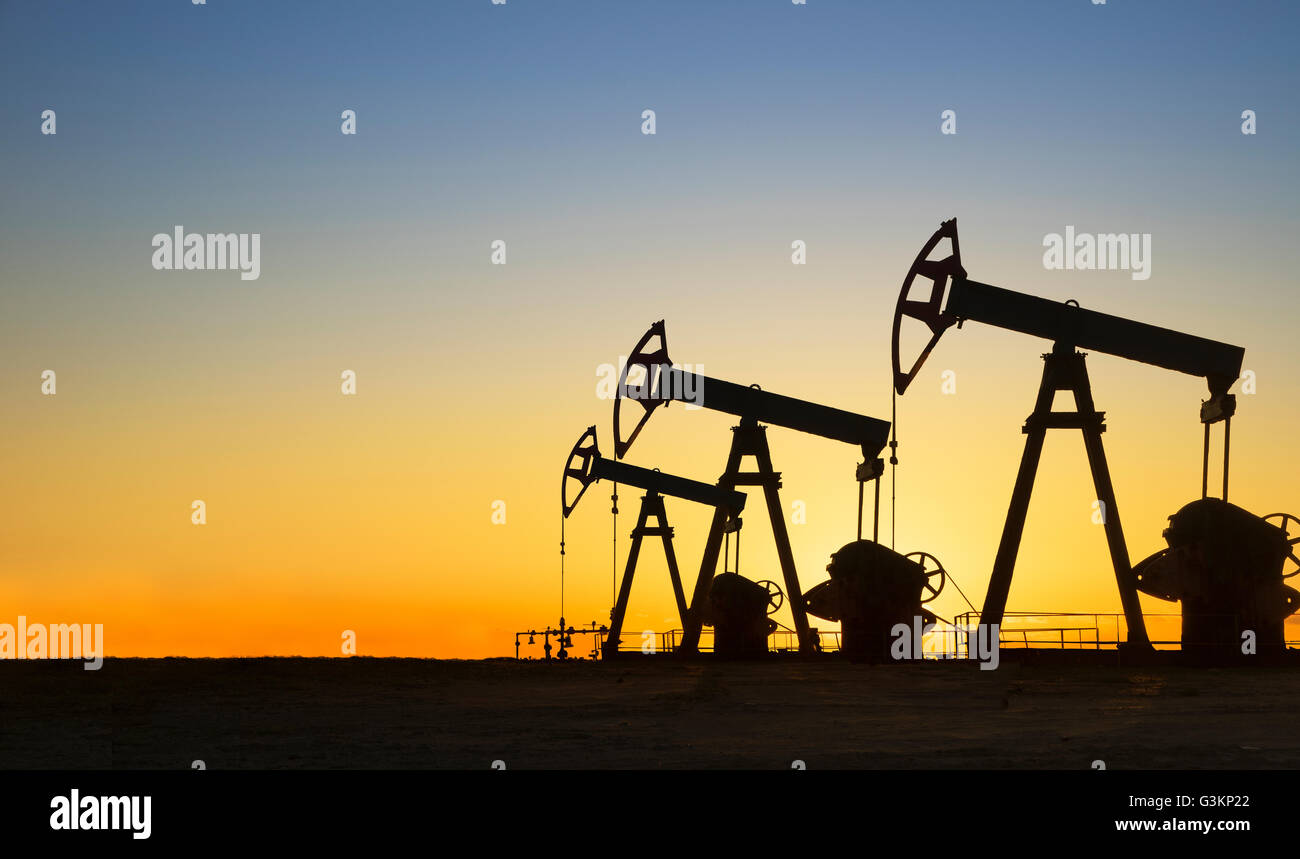 Silhouette of oil wells in desert at sunset, Texas, USA Stock Photo