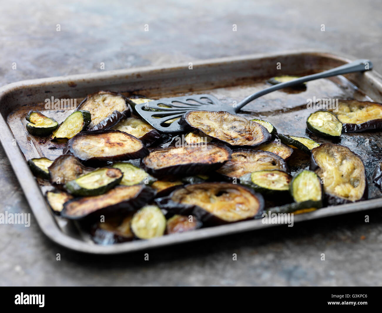 Aubergine slices on baking tray Stock Photo