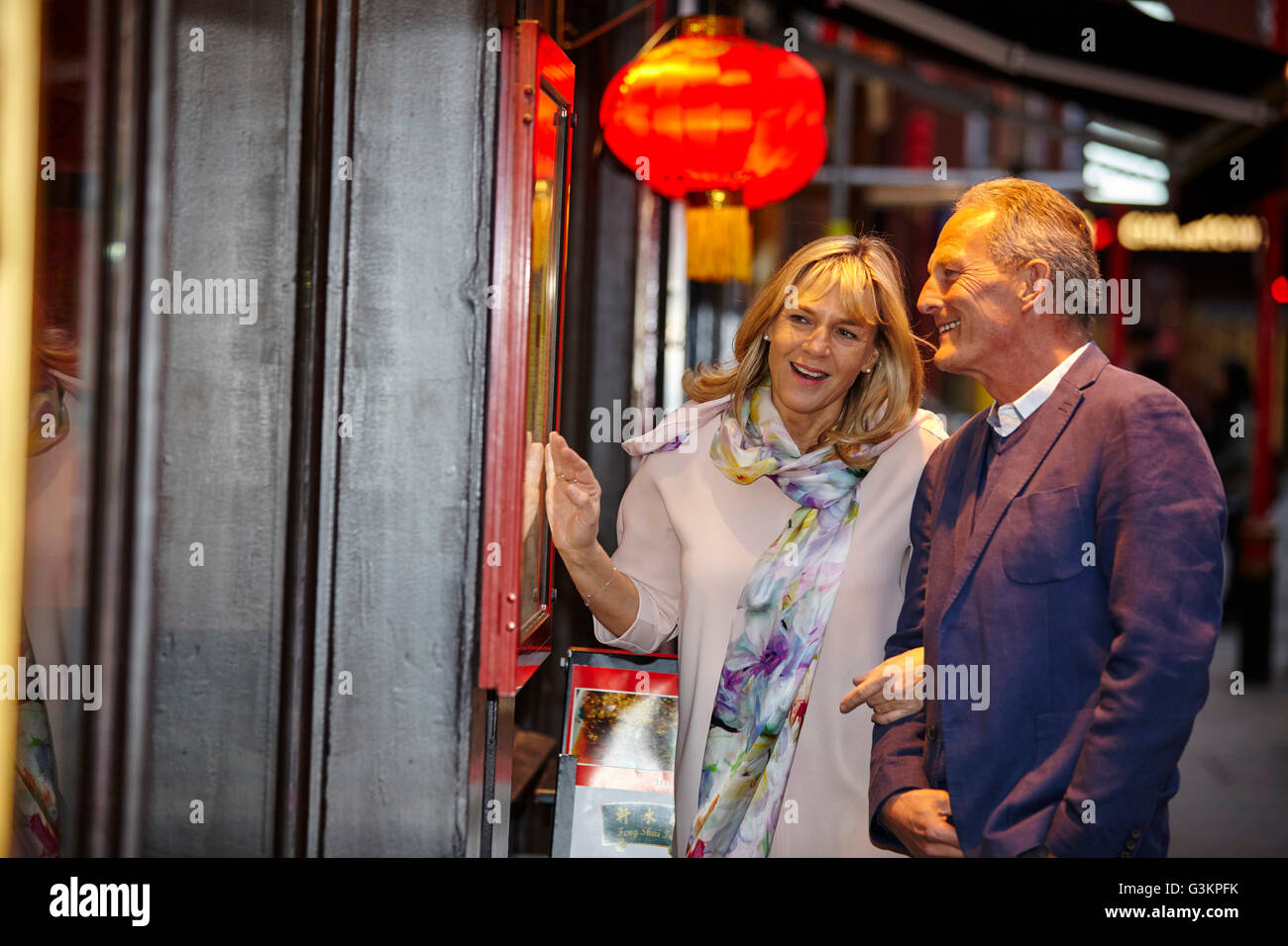 Mature dating couple reading restaurant menu in China Town, London, UK Stock Photo