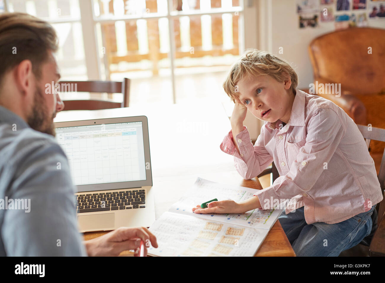Father helping son with homework in home office Stock Photo - Alamy