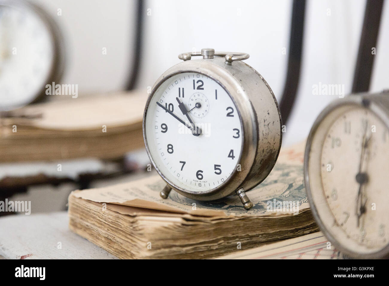 Alarm clock on weathered books Stock Photo