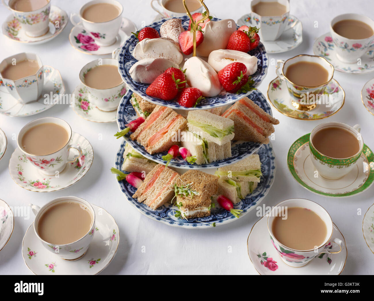 Vintage tea cups and sandwiches on cakestand prepared for afternoon tea Stock Photo