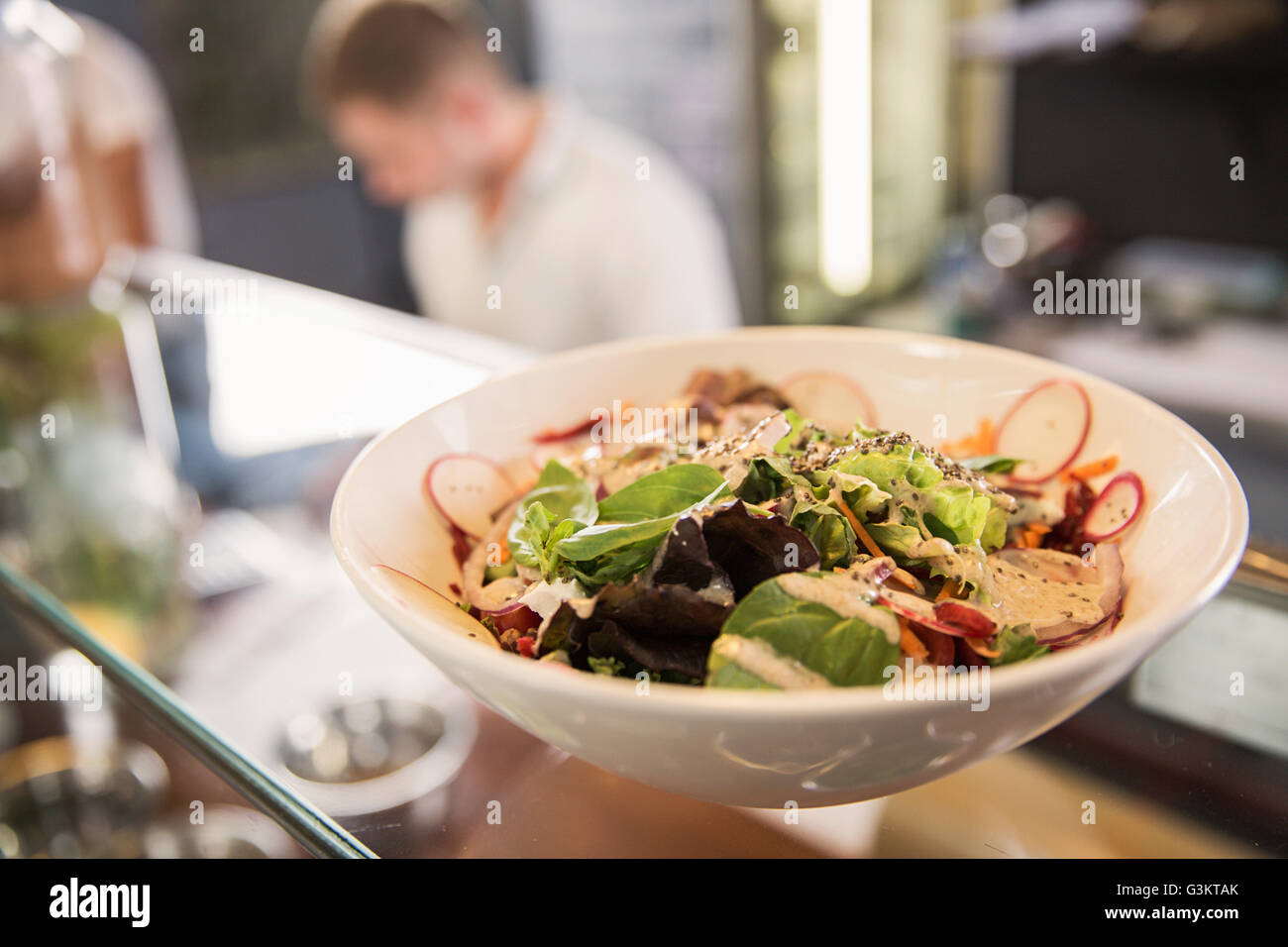Bowl of salad on glass counter in restaurant Stock Photo