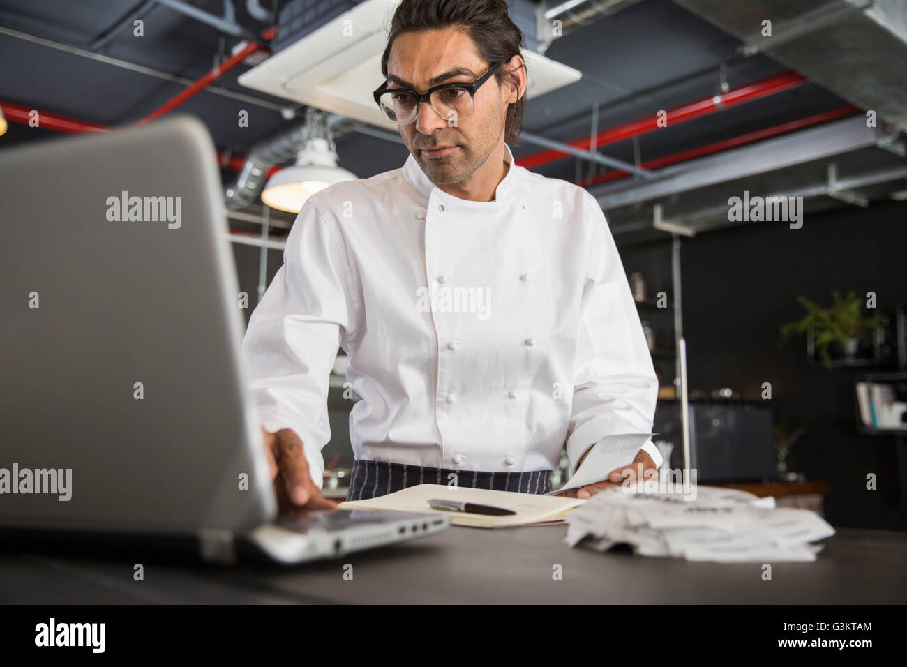 Chef in restaurant using laptop Stock Photo
