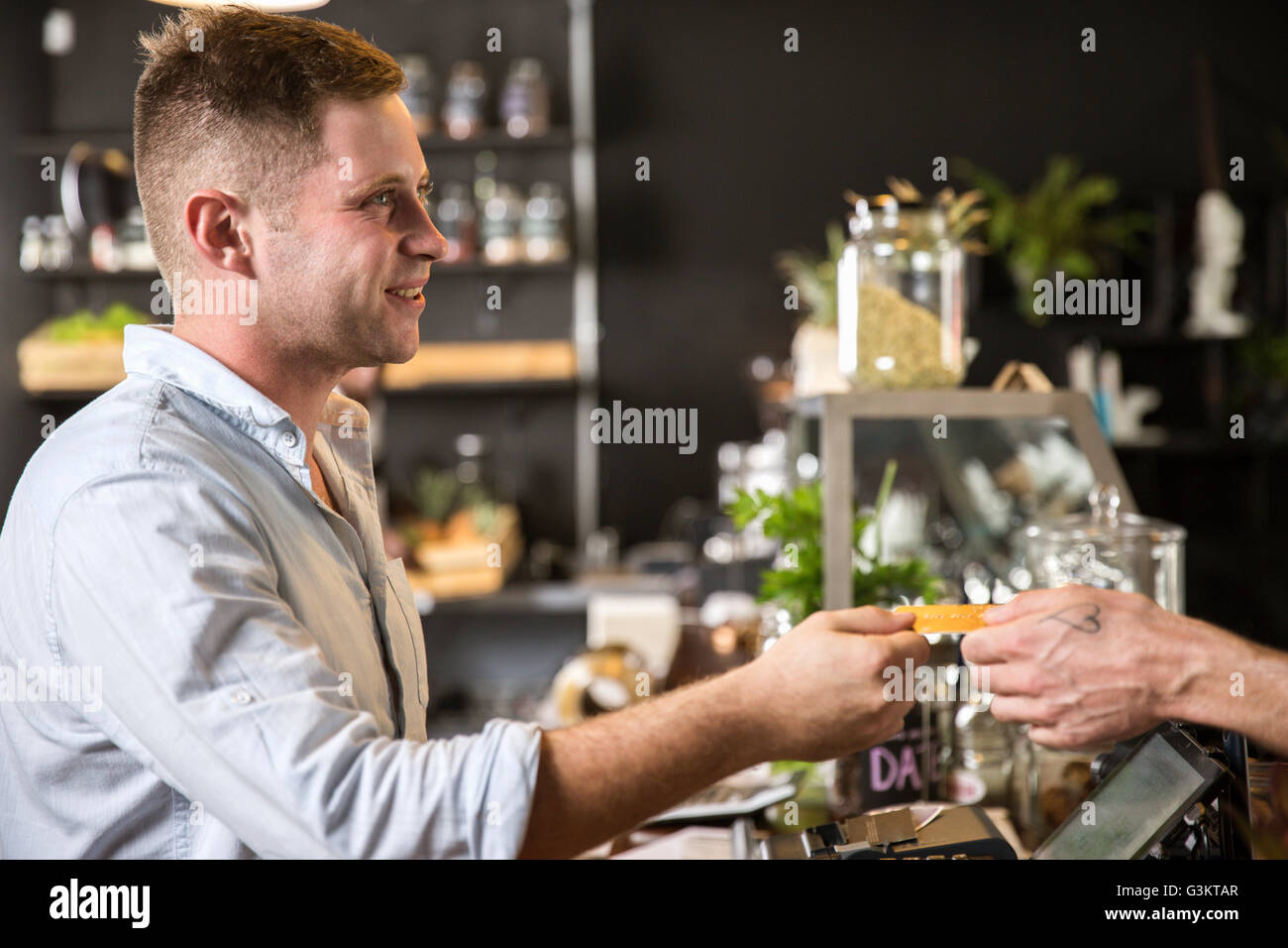 Customer handing smiling restaurant worker credit card Stock Photo
