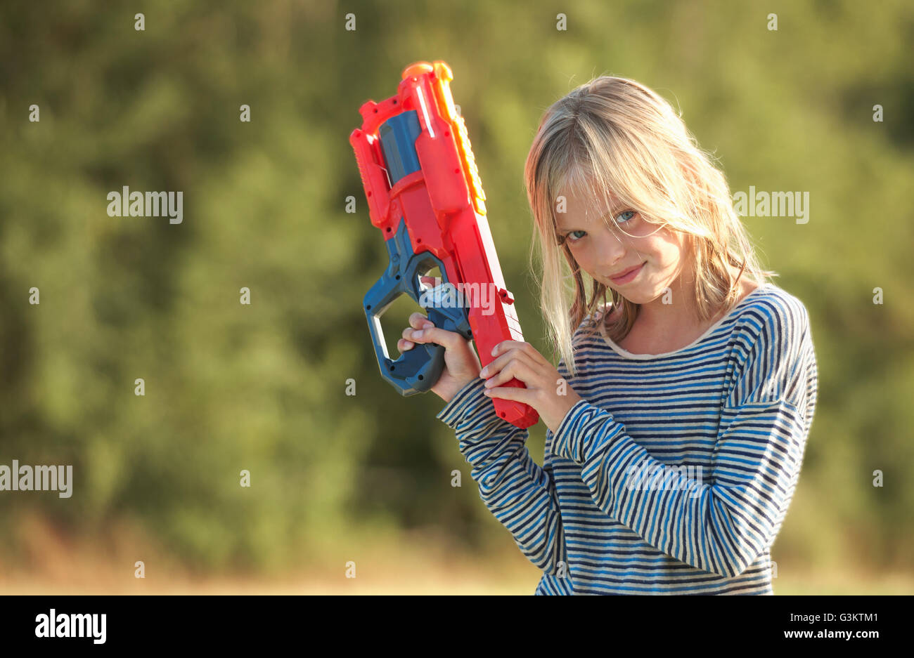 Portrait of girl holding water gun, Buonconvento, Tuscany, Italy Stock Photo