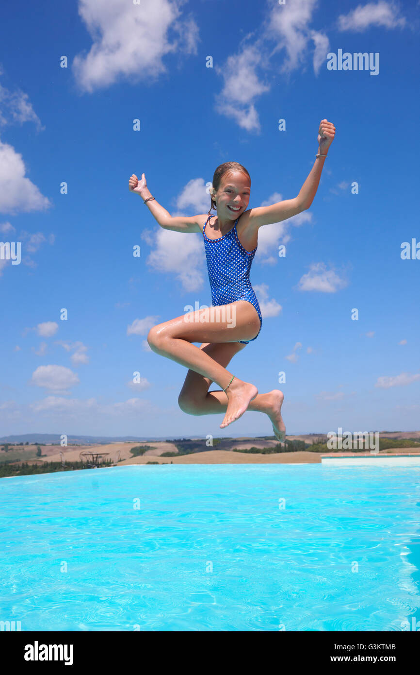 Girl jumping into swimming pool, Buonconvento, Tuscany, Italy Stock Photo