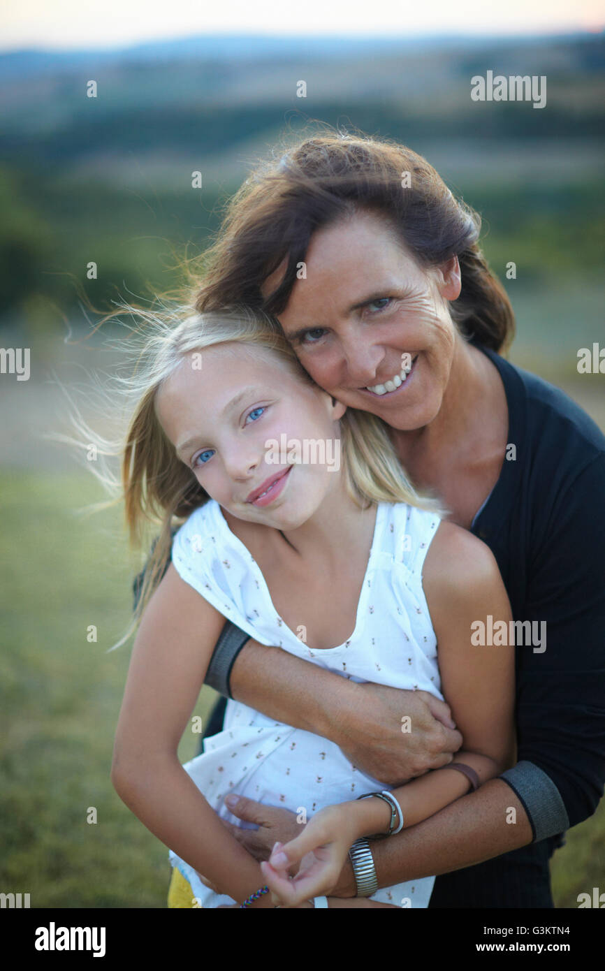 Portrait of senior woman hugging granddaughter, Buonconvento, Tuscany, Italy Stock Photo