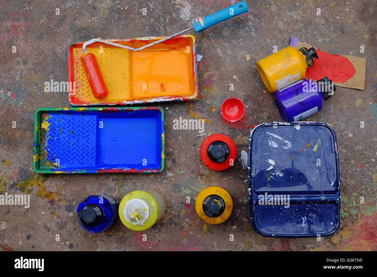 Overhead view of blue and yellow paint trays and paint roller Stock Photo