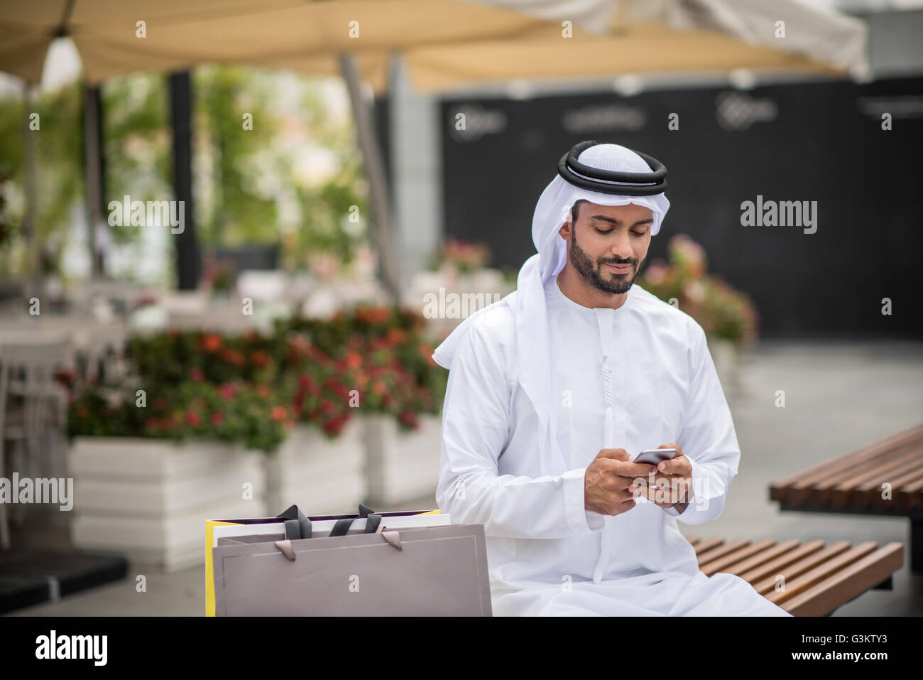 Male shopper wearing traditional middle eastern clothing sitting on