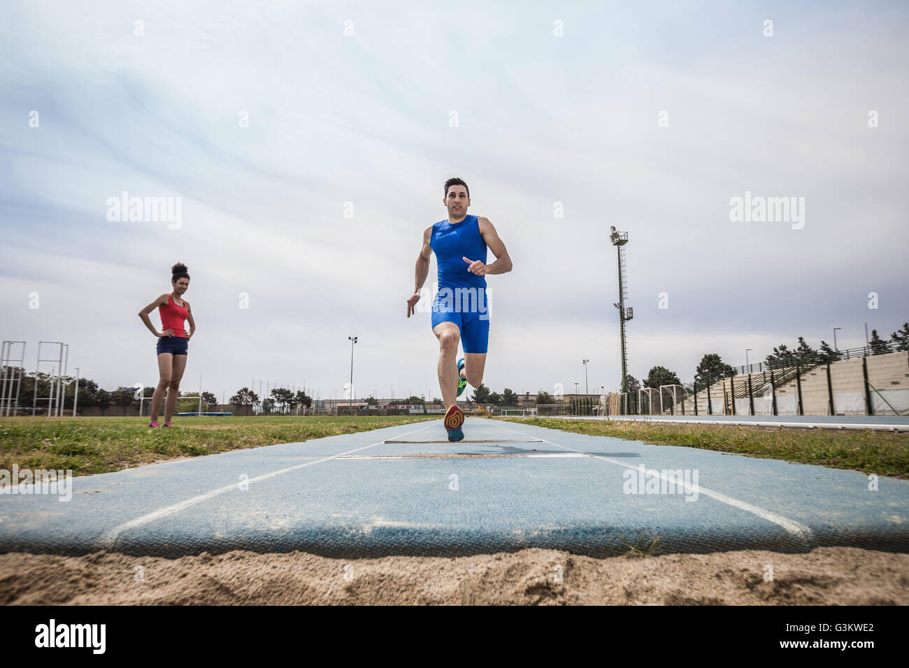 Young male long jumper sprint training at sport facility Stock Photo