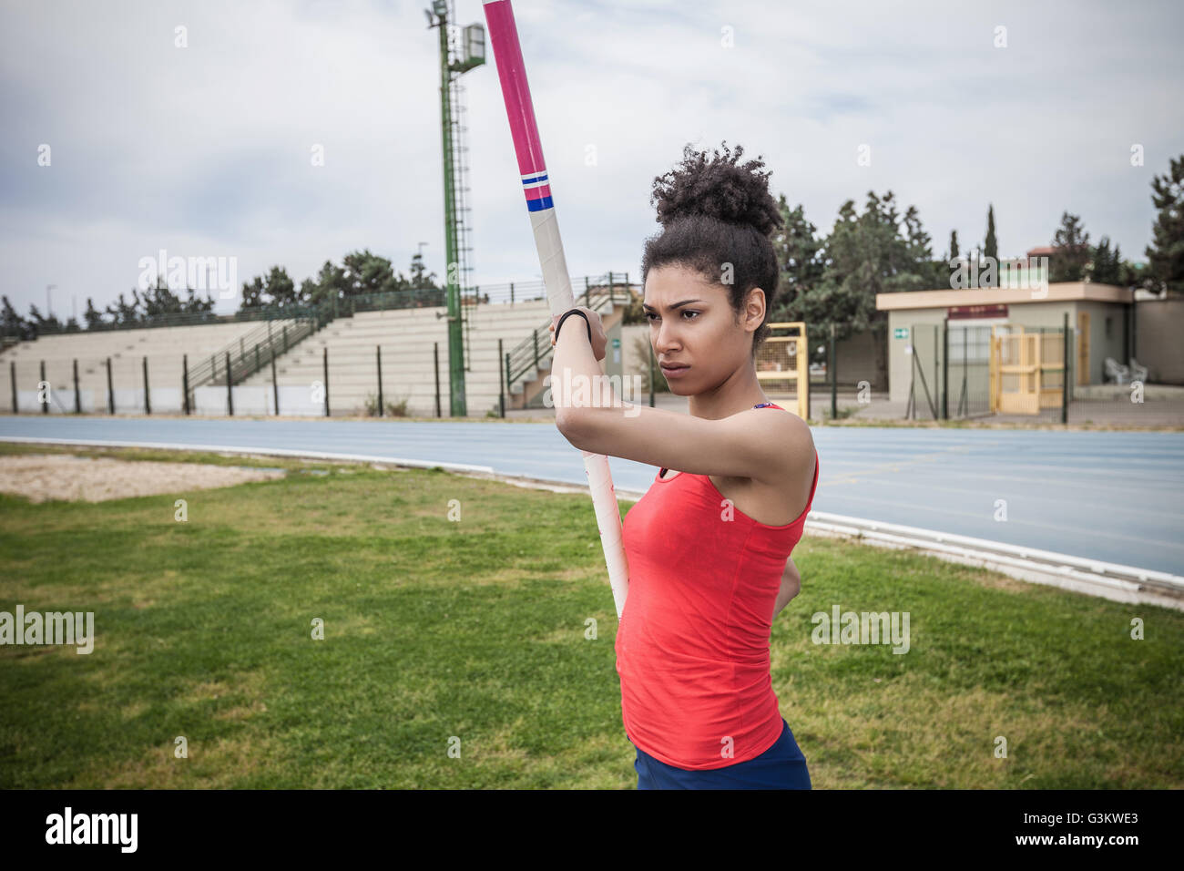 Young female pole vaulter concentrating at sport facility Stock Photo