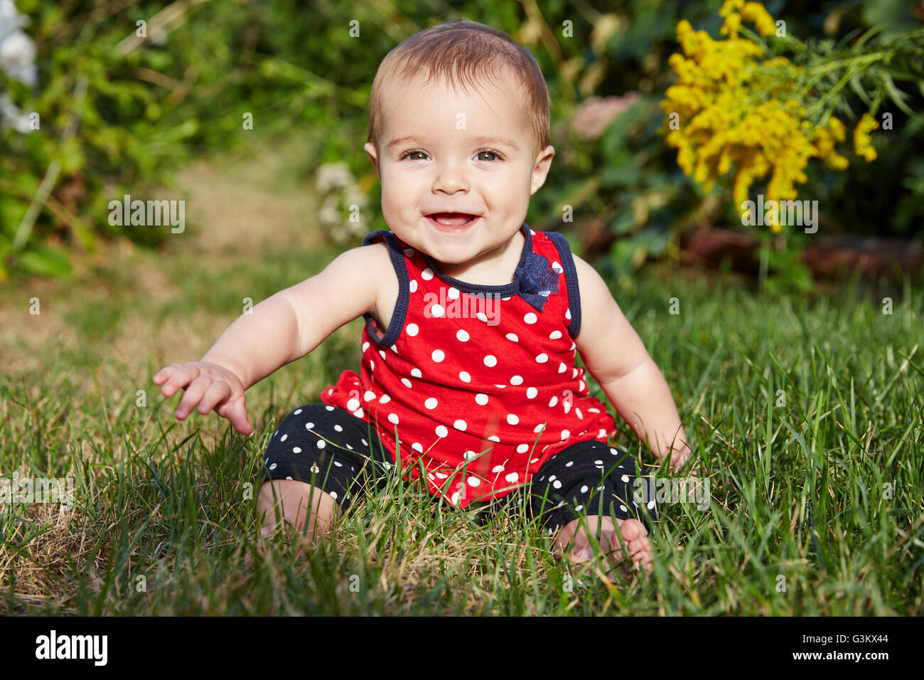 Baby Girl Sitting on Grass Smiling Stock Photo - Alamy
