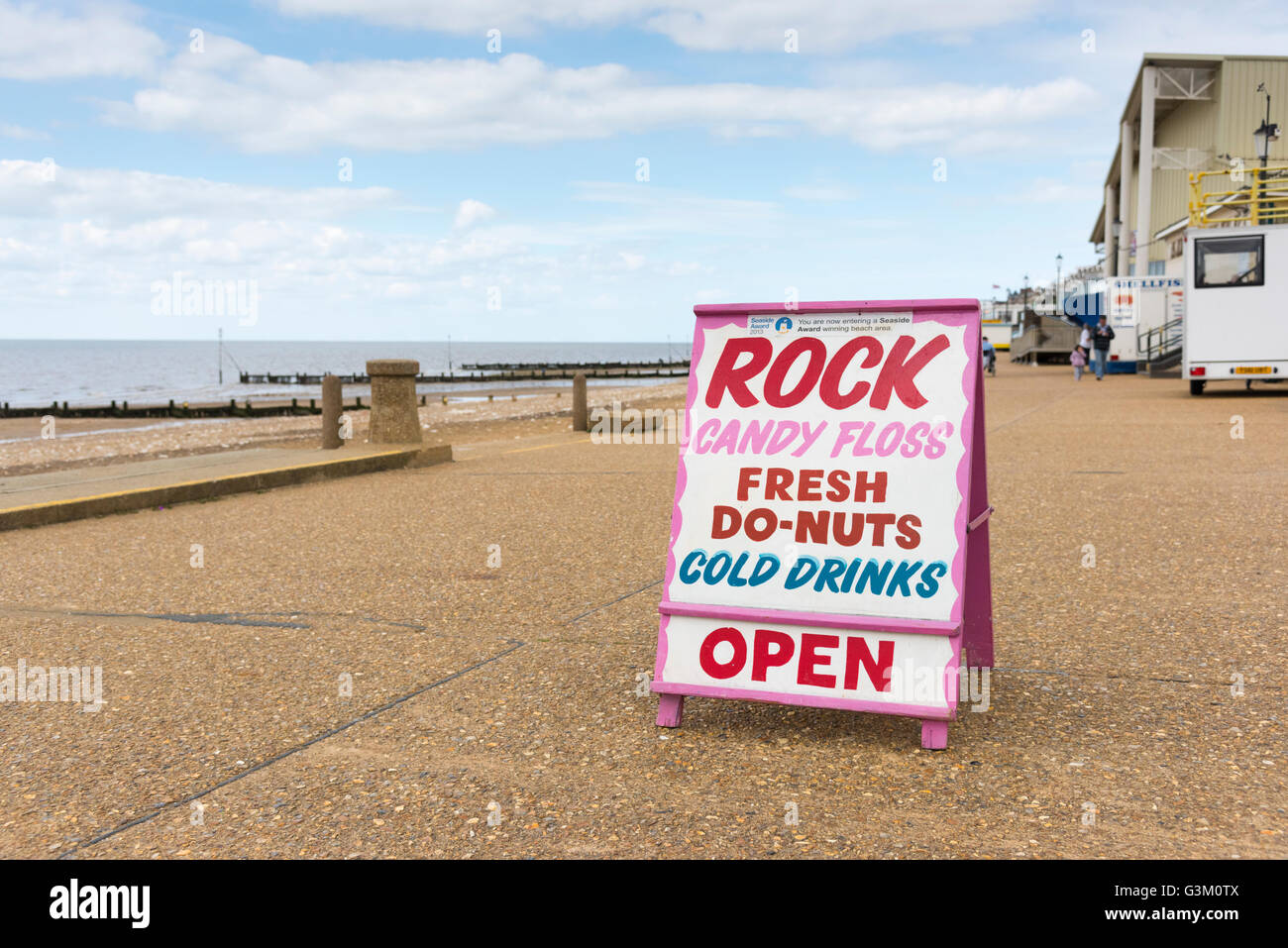 An advertising board for a seaside rock, candy floss and donut stall at Hunstanton Norfolk UK Stock Photo
