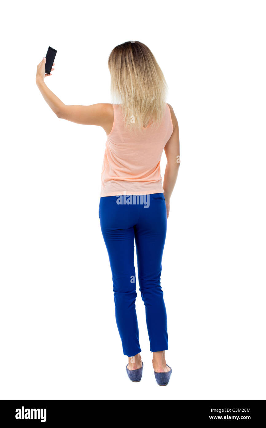 back view of standing young beautiful woman and using a mobile phone ...