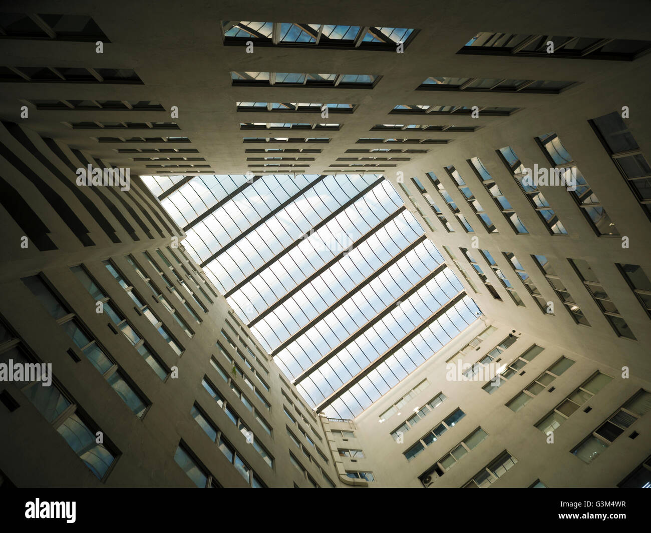 Looking up to the bright light sky through modern quardrilateral ceiling window Stock Photo