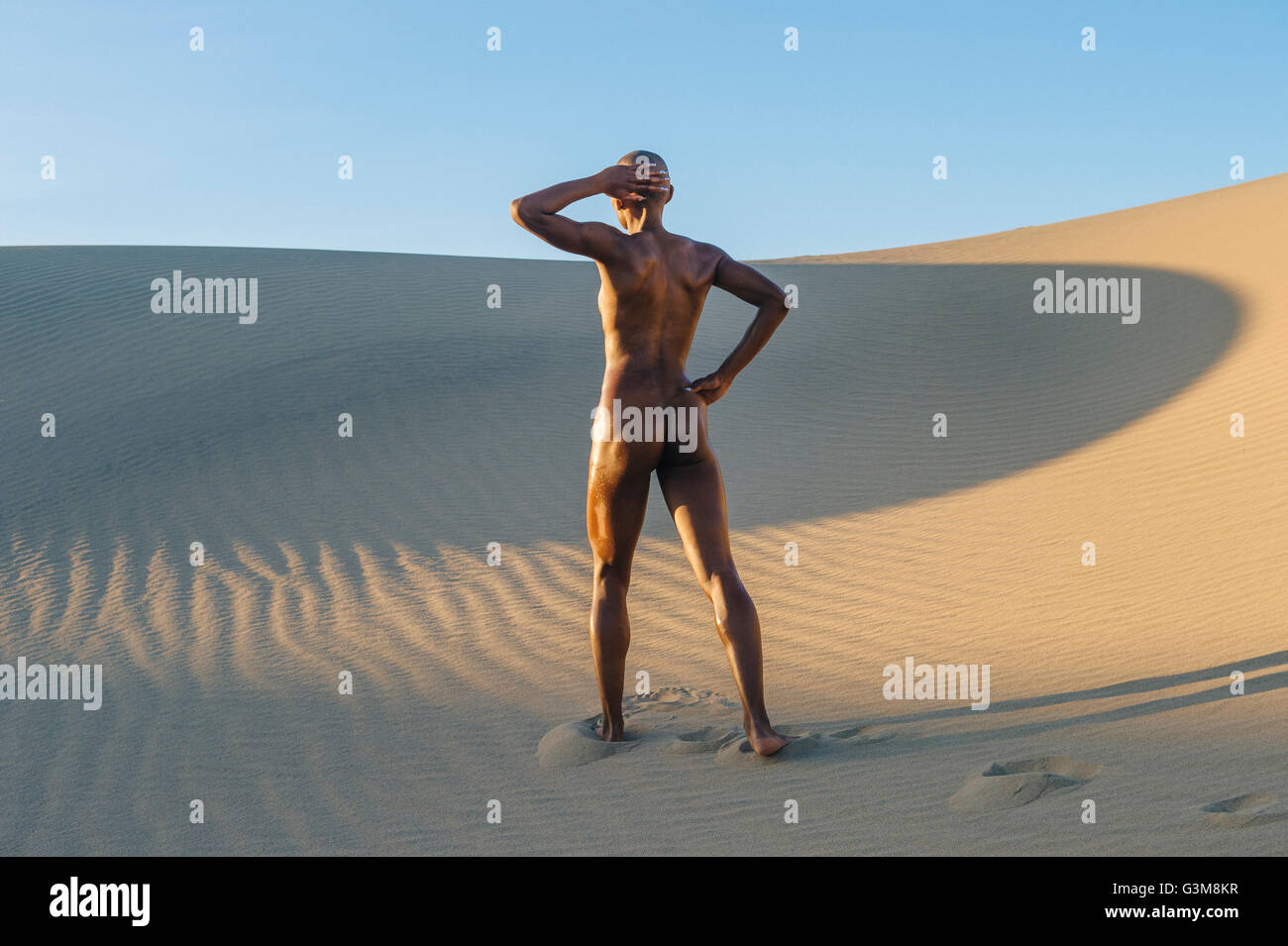 Nude woman standing in desert Stock Photo