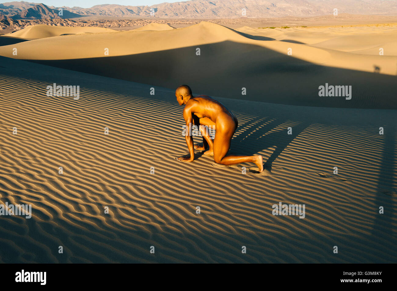 Nude woman in start position in dessert Stock Photo