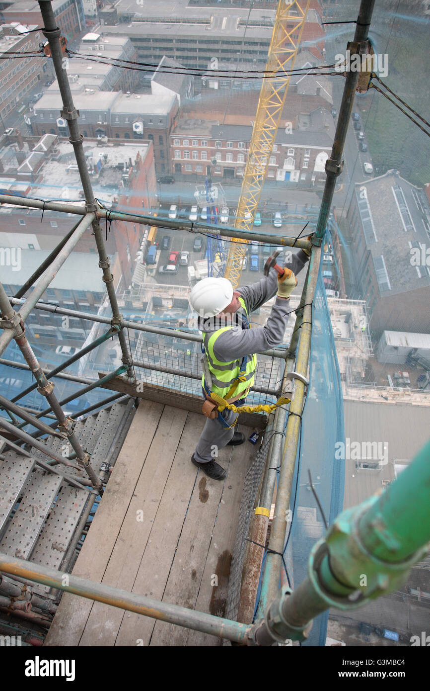 A scaffolder works on a temporary staircase near the top of a tall tower block in Birmingham