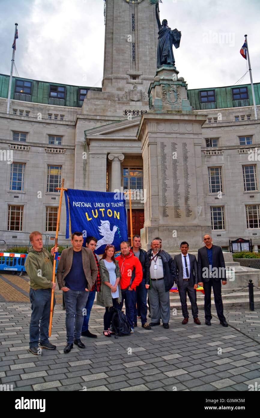 Luton,England. June 13rd, 2016. The National Union of Teachers, Luton branch showing flag. Mourners place rainbow Flowers and rainbow flag in mourning, at Luton`s central war memorial, in the city centre in front of the Luton council building, in tribute to the victims of this weekend's mass shooting in Orlando, Florida. At least 52 people were killed in the shooting, and another 51 wounded. The perpetrator, named as Omar Mateen, had reportedly pledged allegiance to the Islamic State terror group. .. Credit:  Remo Kurka/Alamy Live News Stock Photo