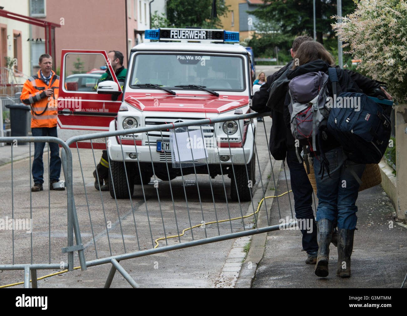 Waldkirch, Germany. 14th June, 2016. Evacuated residents take urgently needed things from the house in a backpack in Waldkirch, Germany, 14 June 2016. Around 30 centimeters of mud lie on the street following a landslide. Four houses needed to be evacuated. Photo: PATRICK SEEGER/dpa/Alamy Live News Stock Photo