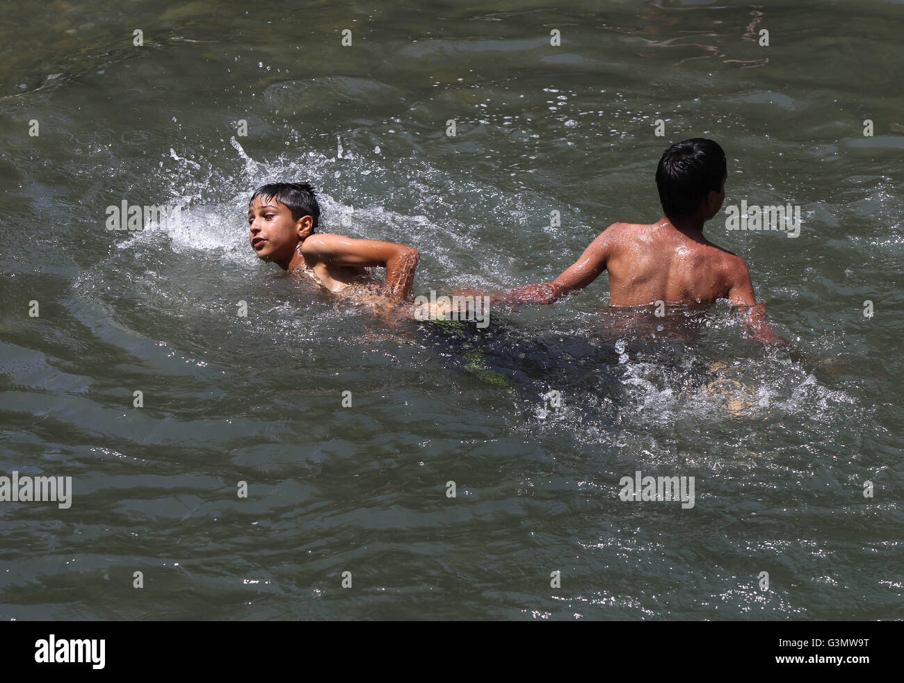 Srinagar, Indian-controlled Kashmir. 14th June, 2016. Kashmiri children bathe in a stream on a hot summer day on the outskirts of Srinagar, summer capital of Indian-controlled Kashmir, June 14, 2016. As Indian-controlled Kashmir witnessed hot weather for the past few days, people took shower in streams to beat the heat. Credit:  Javed Dar/Xinhua/Alamy Live News Stock Photo