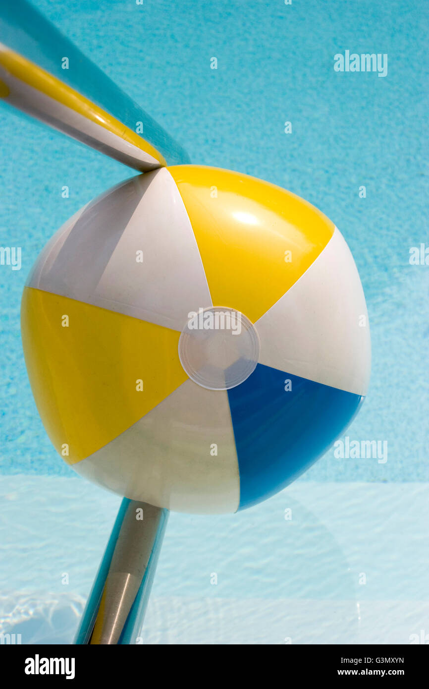 Inflatable blue, white and yellow beach ball in swimming pool Stock Photo