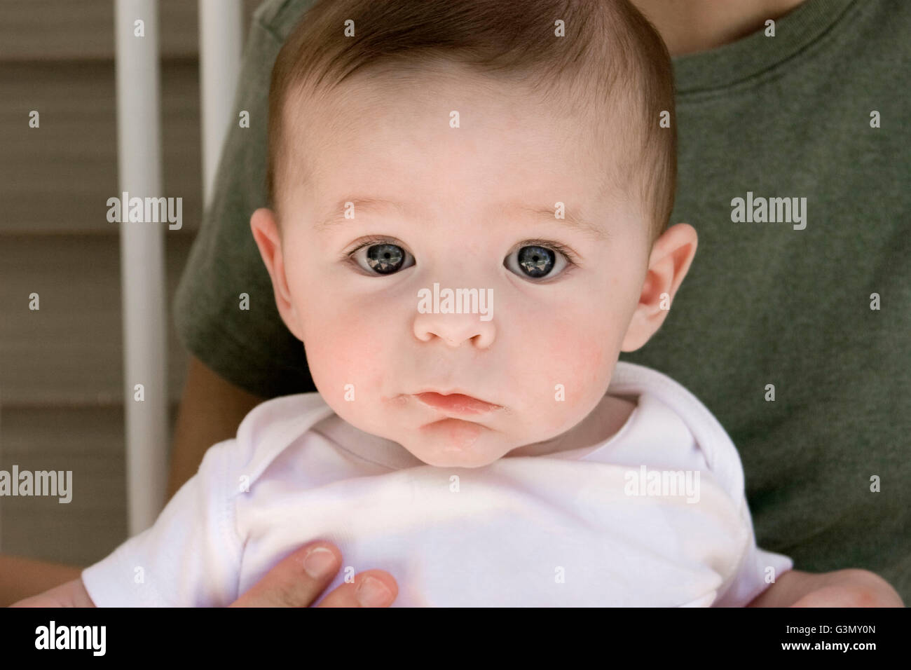 5-month old baby boy sitting in his Mother's lap Stock Photo