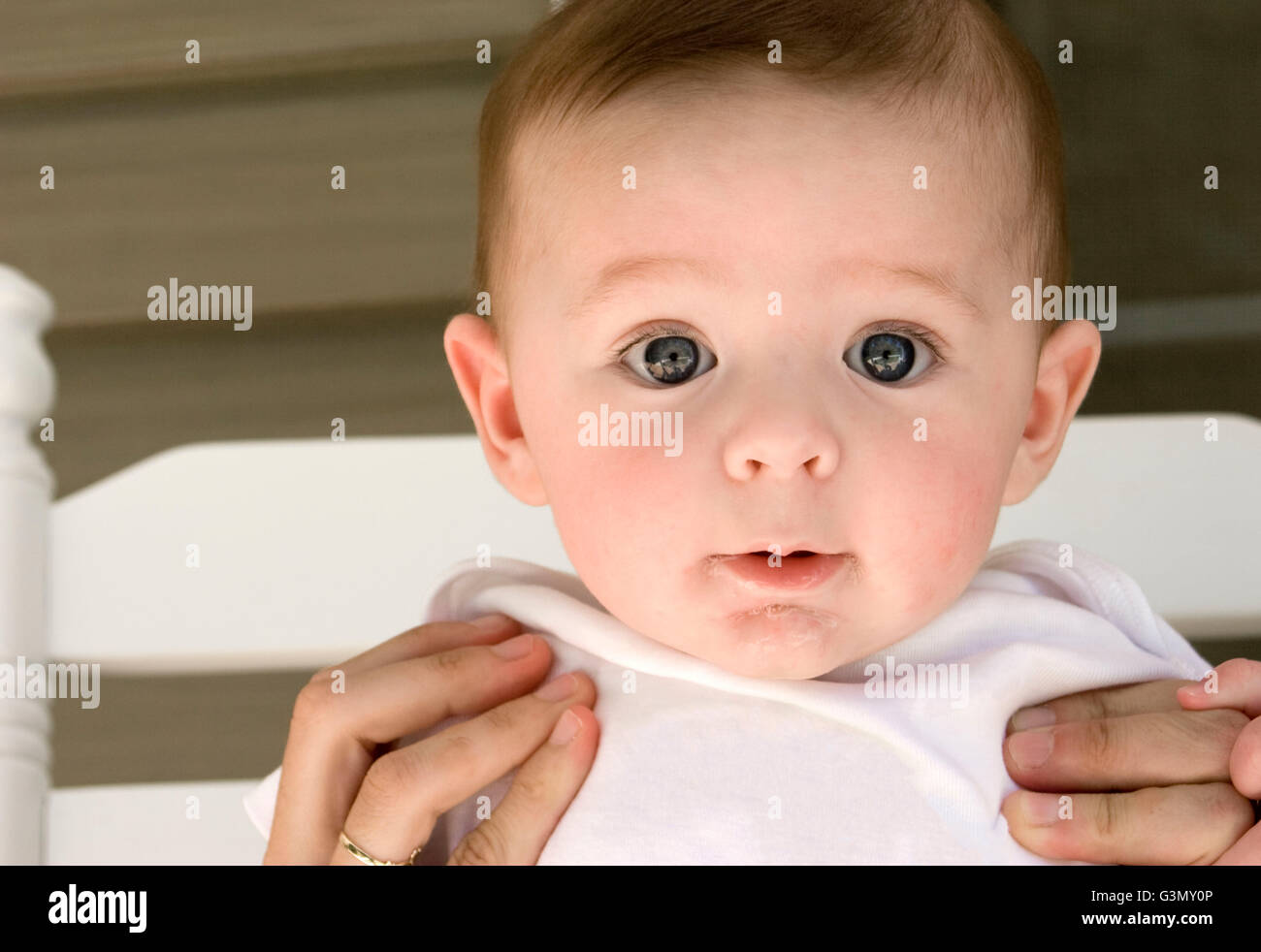 5-month old baby boy being held up by his mother Stock Photo