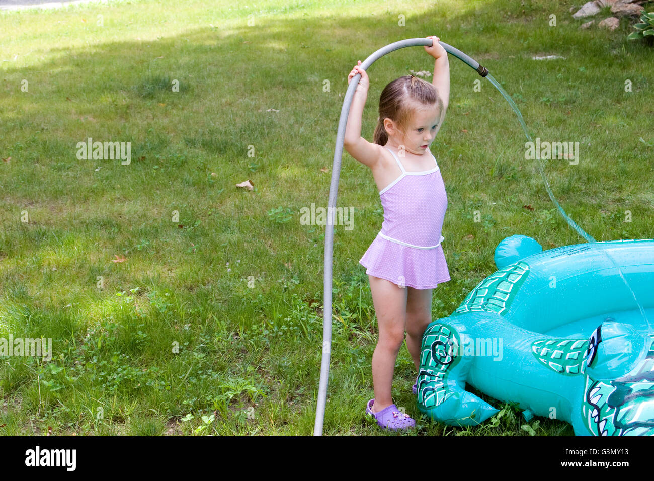 4year old girl filling an inflatable pool with water Stock Photo Alamy