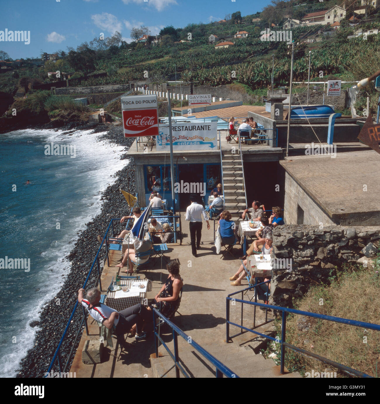 Mittagessen im Fischrestaurant Toca do Polvo am Strand von Funchal, Madeira, Portugal 1980. Lunch in the fish restaurant Toca do Polvo at the beach of Funchal, Madeira, Portugal 1980. Stock Photo