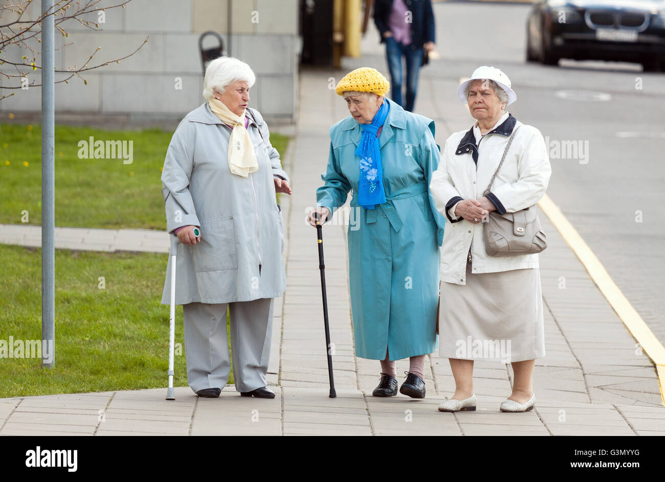 Three aged senior women walking on the street and talking Stock Photo