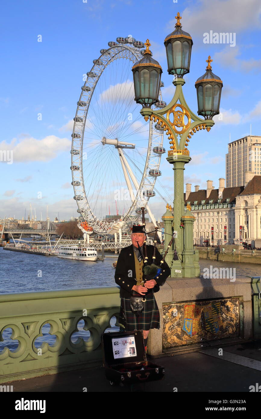 Scottish musician playing bagpipes at sunset on Westminster Bridge with ...