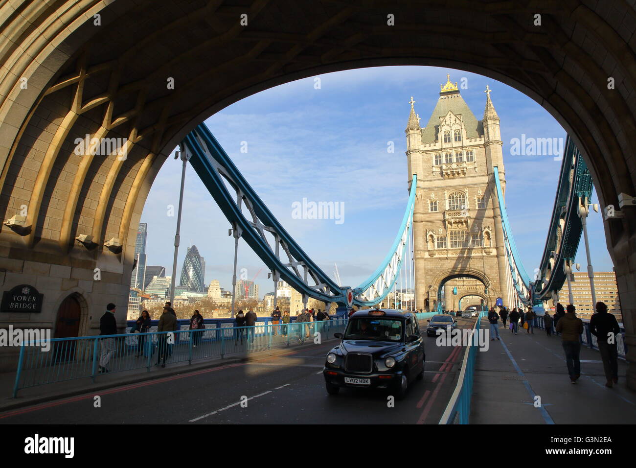 A black taxi cab on the Tower Bridge with Winter colors, London, Great Britain, the Gherkin in background Stock Photo