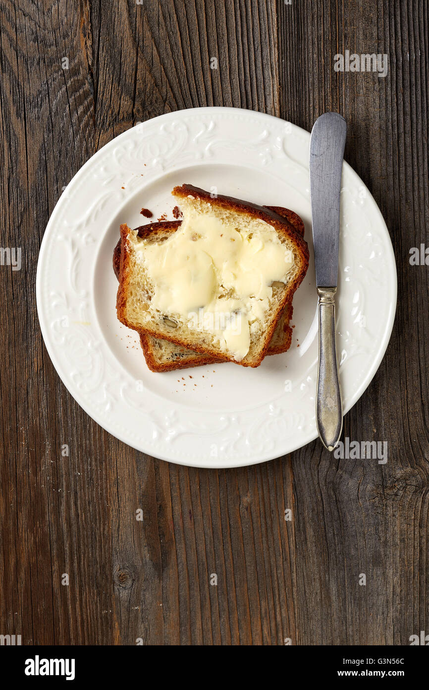 Healthy grain bread with butter on wooden table, top view Stock Photo