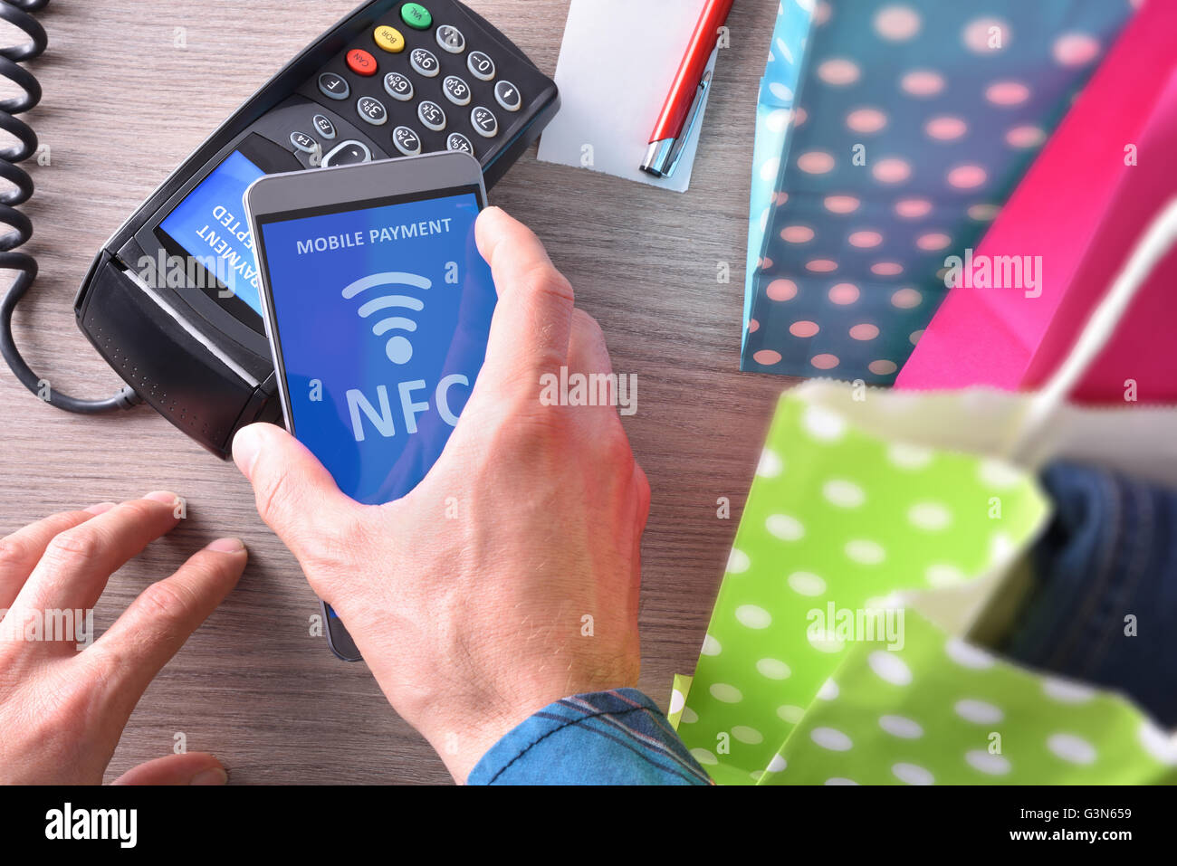 Payment in a trade with nfc system with mobile phone. Top view,vertical composition Stock Photo