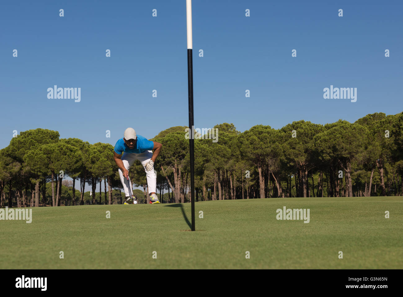 golf player aiming shot with club on course at beautiful sunny day ...