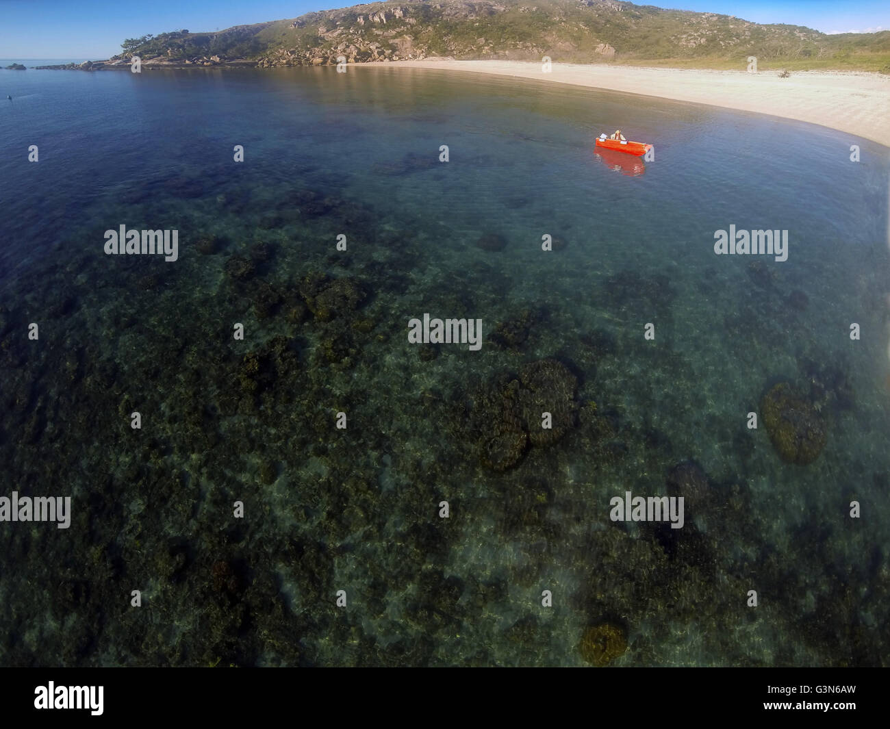 Small red boat in Mermaid Bay, Lizard Island, Great Barrier Reef, Queensland, Australia. No MR or PR Stock Photo