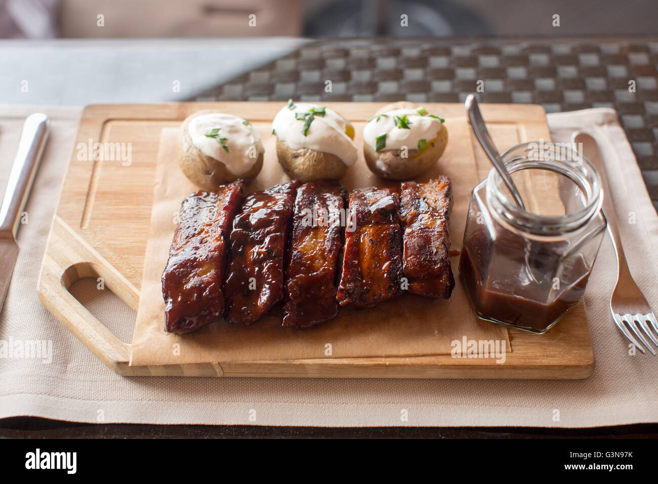 Board of barbecue ribs and potatoe on wooden Stock Photo
