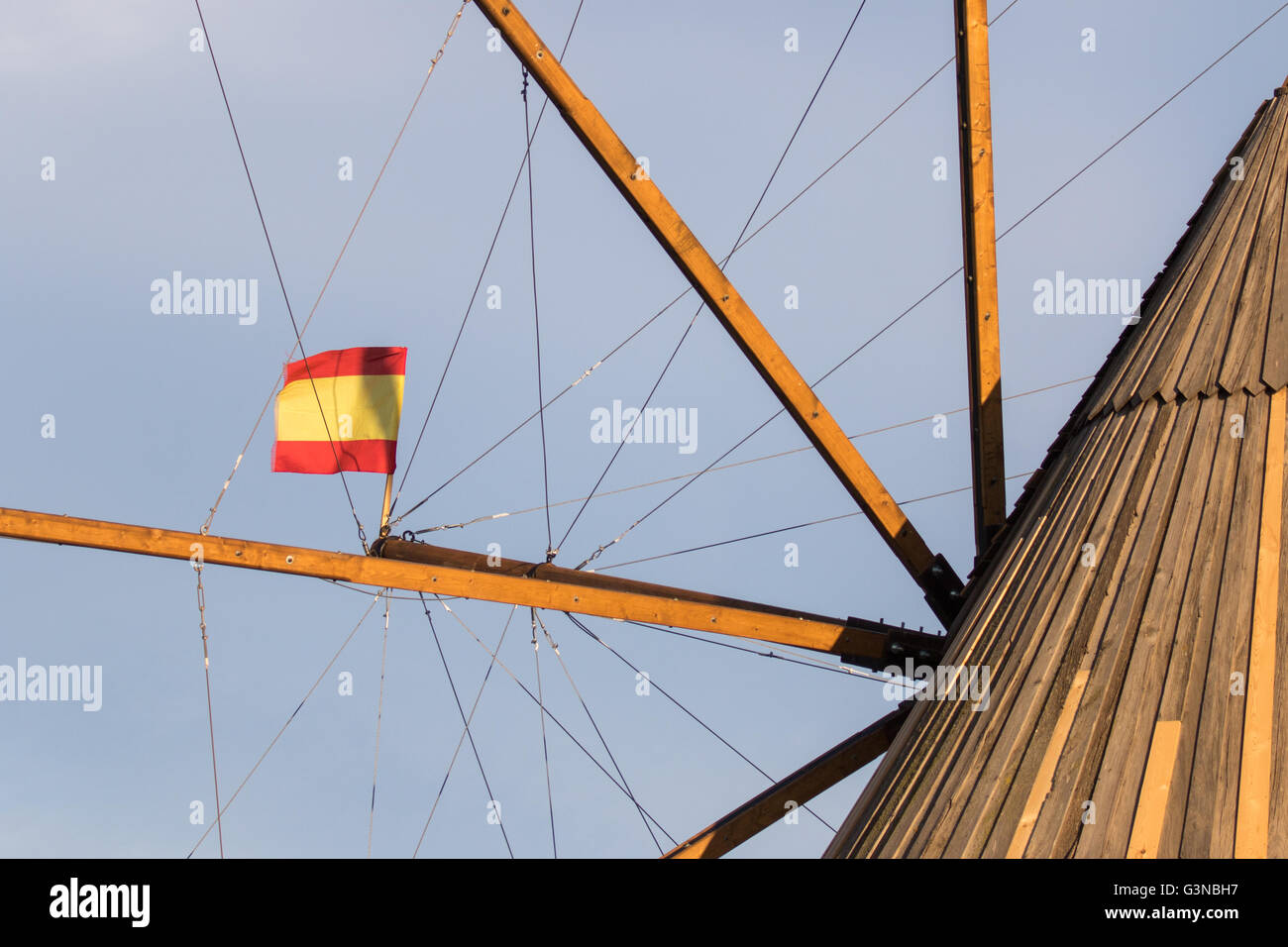 Close up of the top of an old Spanish windmill vanes, with a Spain flag