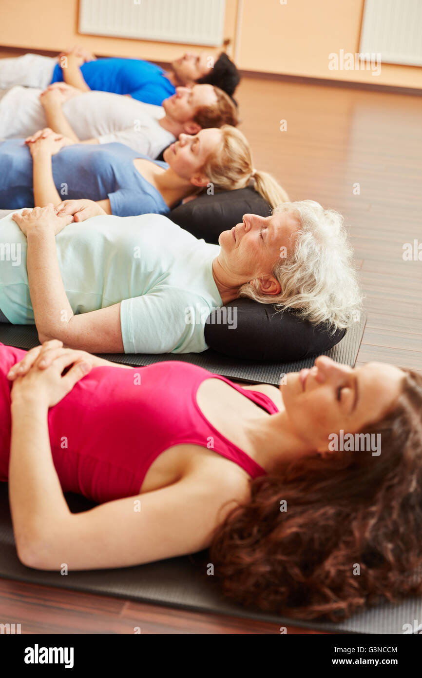 Group meditating for relaxation after yoga class Stock Photo