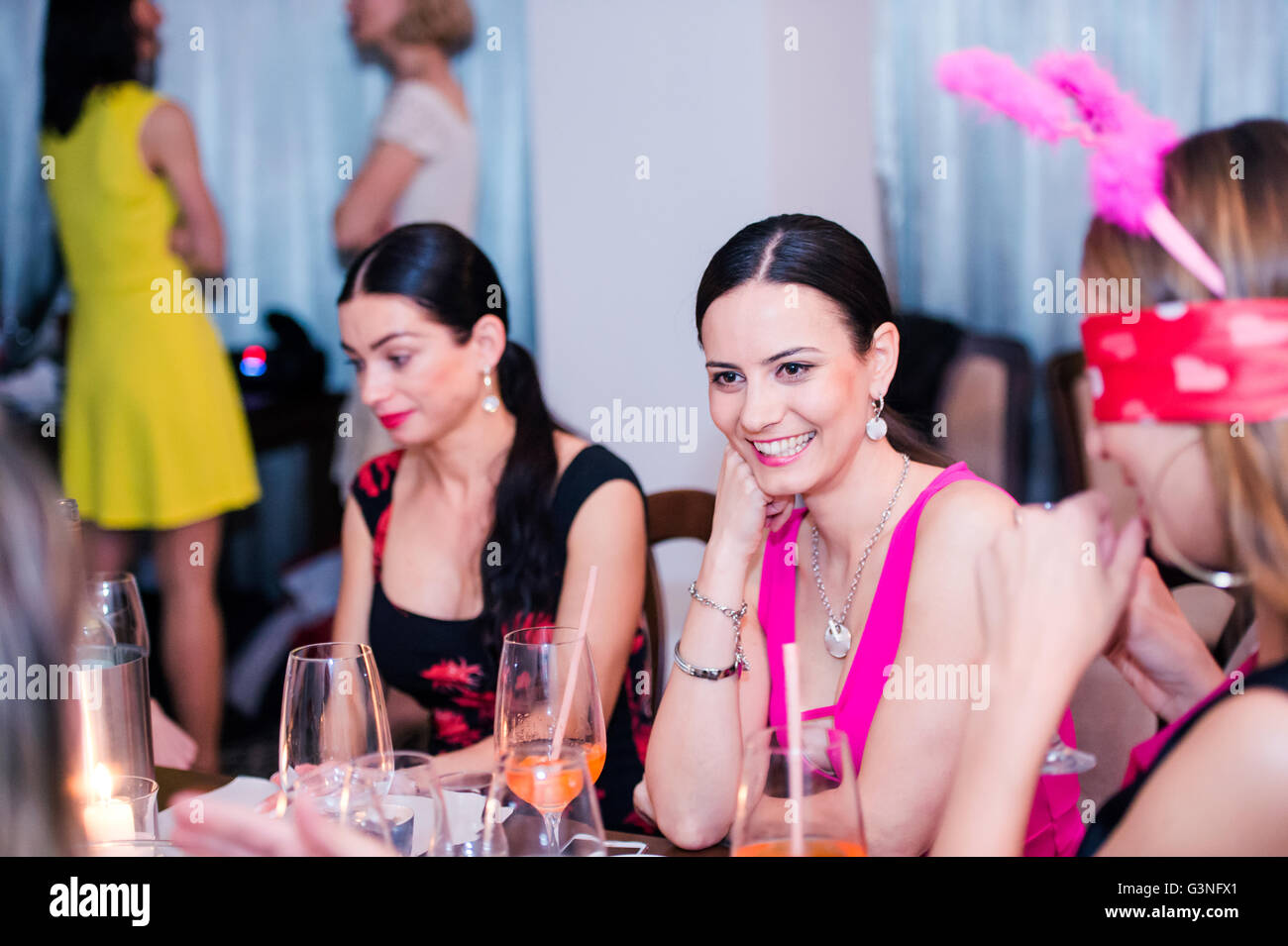 Cheerful bride and bridesmaids celebrating hen party with drinks Stock Photo