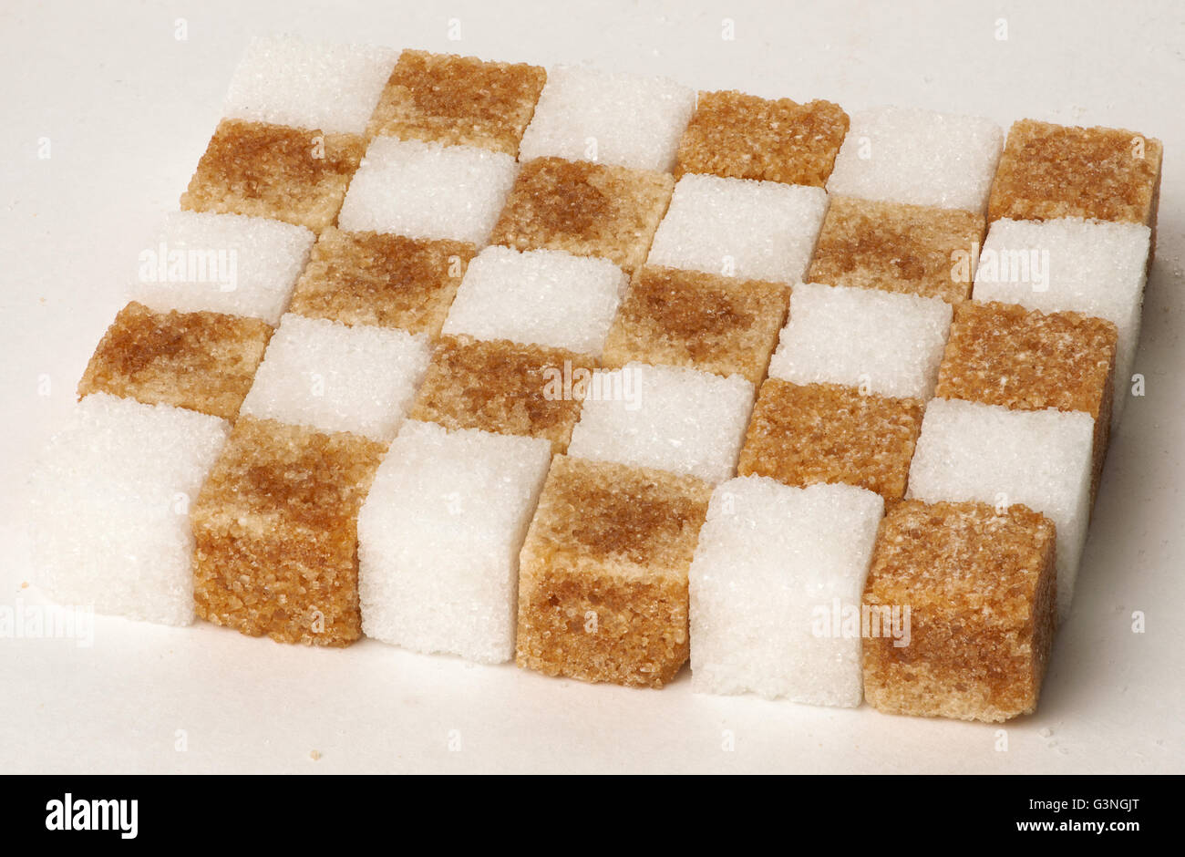Cubes of sugar cane brown and white folded into a checkerboard pattern concept isolated Stock Photo