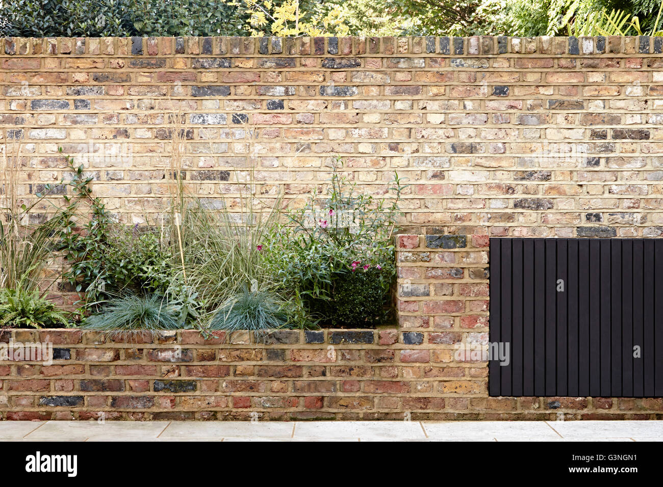 Garden brick wall and storage boxes. Ockendon Road, London, United Kingdom. Architect: Nissen Richards Studio, 2014. Stock Photo